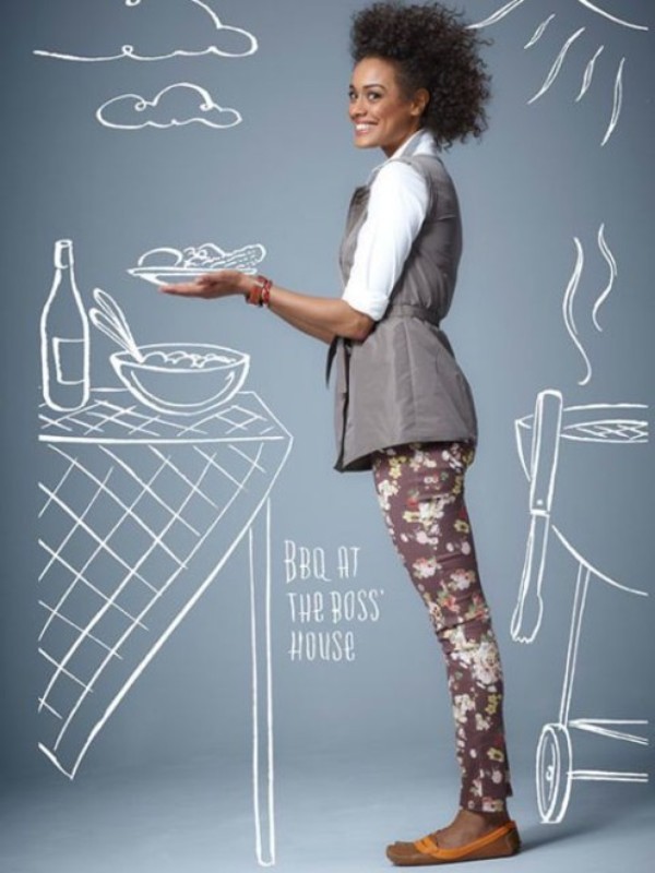 Woman poses with salad on plate in studio, wearing patterned leggings, with a picnic table drawn in white on a grey background.