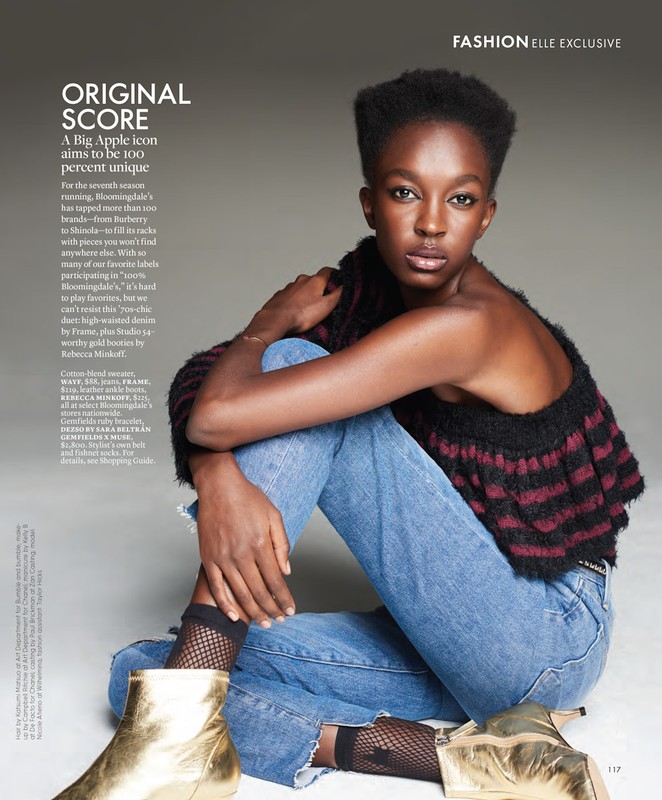 Fashion editorial shot of an African-American woman wearing light blue jeans and metallic gold boots against a neutral grey backdrop.