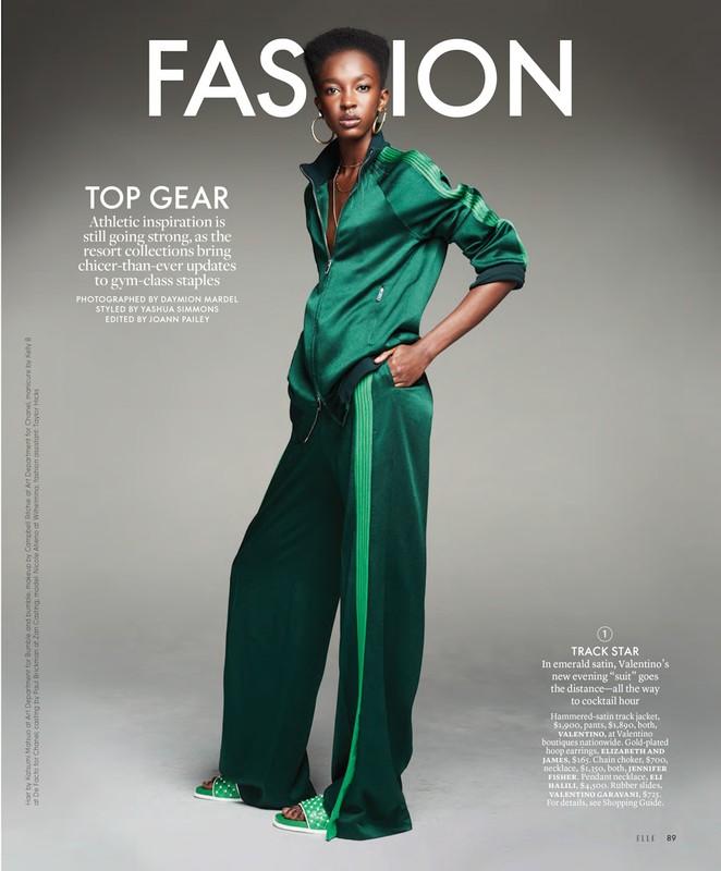 Fashion magazine cover featuring a Black woman in a green satin tracksuit, posing in a studio with earrings and a necklace.