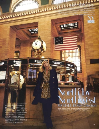 Editorial fashion shoot in Grand Central Terminal with woman in patterned dress, long coat, and dark pants in a large public space.