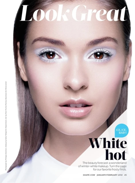 Close-up studio shot of a woman wearing winter-white makeup with glossy lips; beauty and fashion concept for a magazine cover.