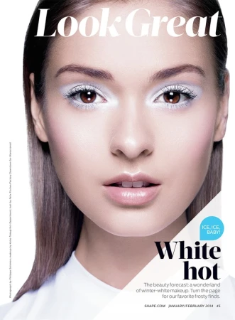 Close-up studio shot of a woman wearing winter-white makeup with glossy lips; beauty and fashion concept for a magazine cover.