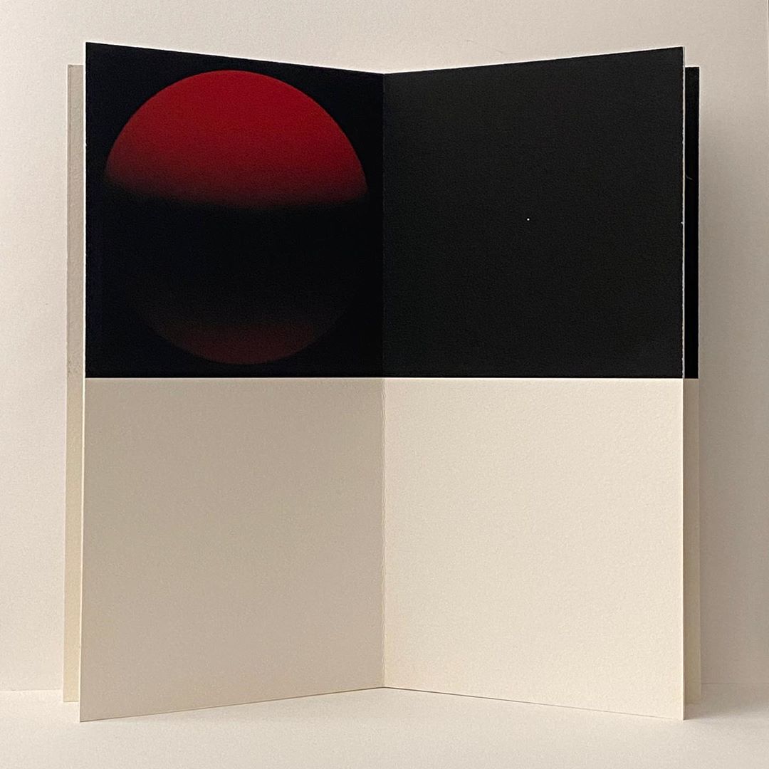 Open book with red circle and black background on upper half, with white space on the lower half of the interior pages.