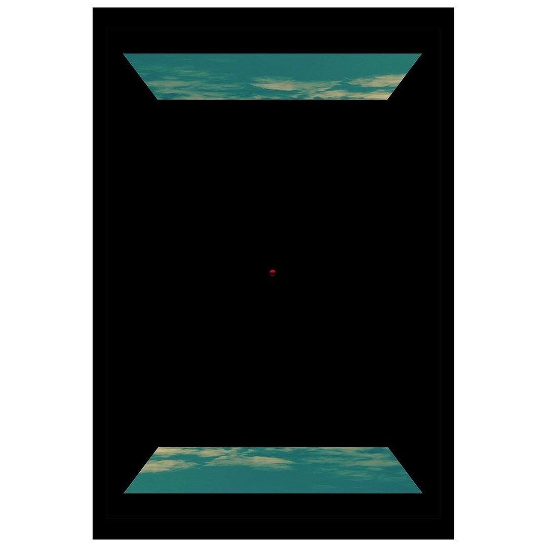 Abstract composition featuring a red sphere in a black void, with rectangular glimpses of a cloudy sky above and below.