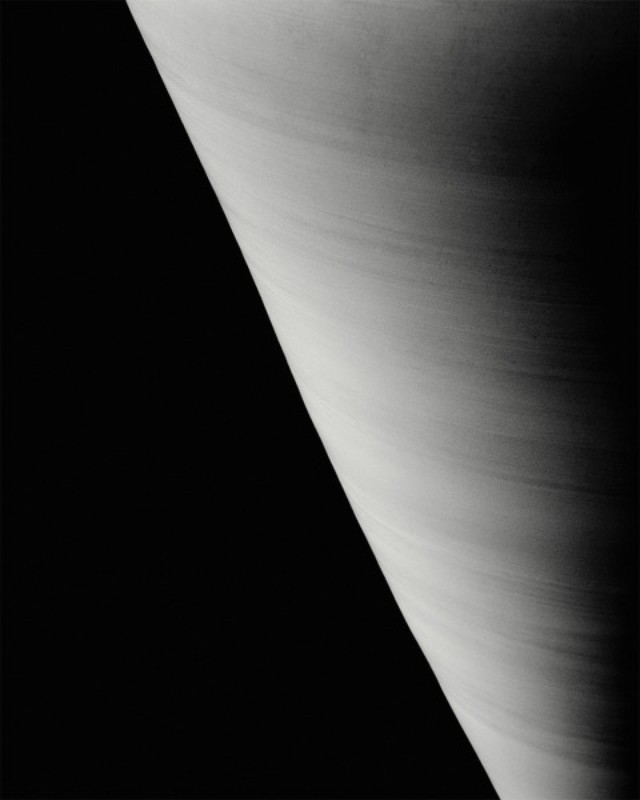 Monochromatic image of planet with striated cloud bands against a dark, stark, contrasting background. High contrast. 