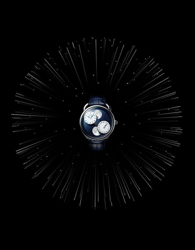Wristwatch with multiple dials on a black background with silver light burst design, showcasing a complex horological design.