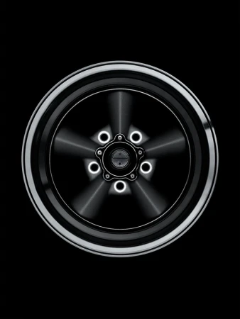 Close-up of a stylized silver and black car wheel with a five-star center design against a dark background, automotive design.