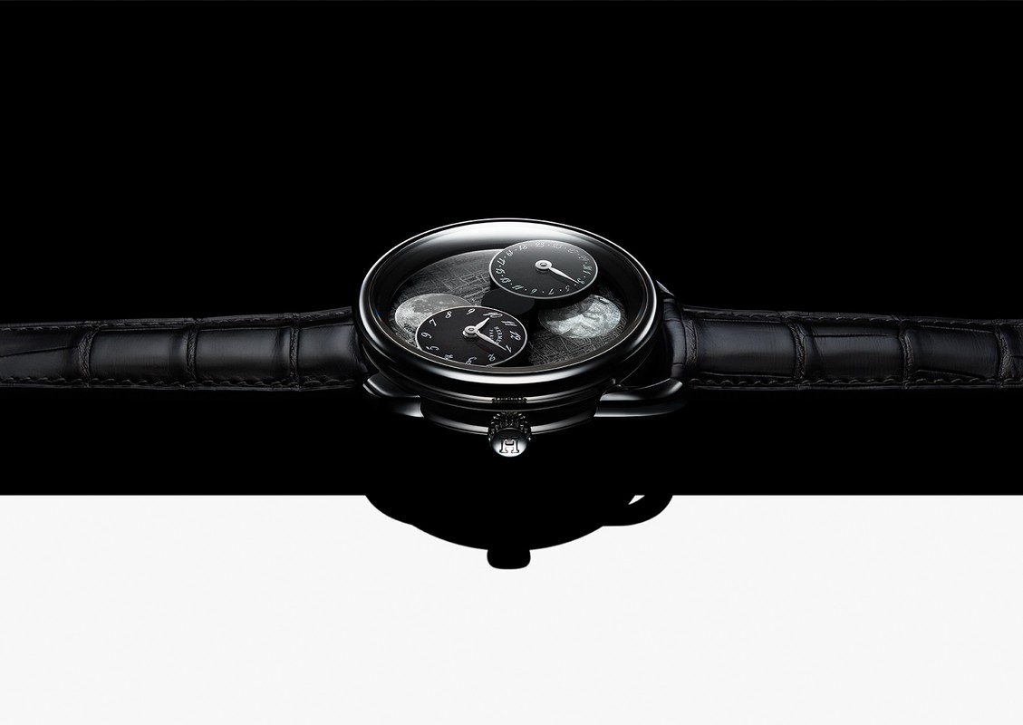 Elegant black wristwatch with a leather band, featuring a sophisticated dial with multiple sub-dials, set against a stark black and white background.