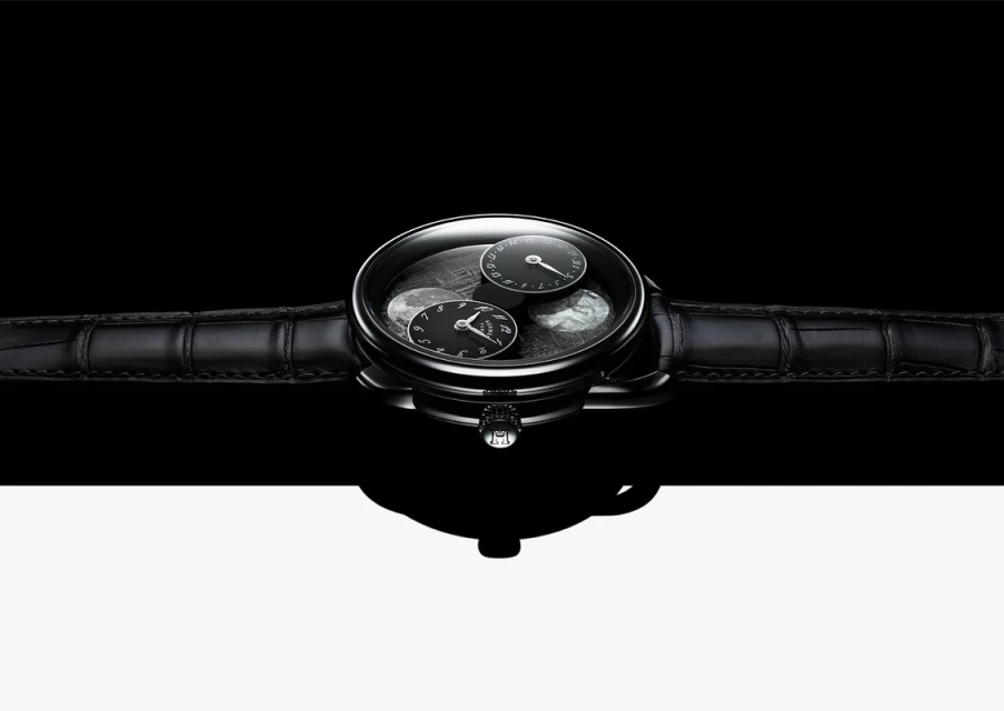 Elegant black wristwatch with a leather band, featuring a sophisticated dial with multiple sub-dials, set against a stark black and white background.