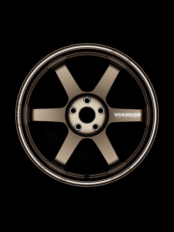 Bronze-toned six-spoke car wheel with silver rim on black backdrop, automotive part, transportation design, aftermarket car product photography.