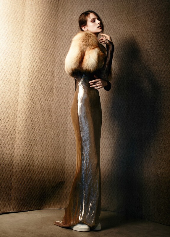 Fashion shot of a woman in a shimmering gown with a fur stole, showcasing a blend of classic glamour and modern runway style in studio.