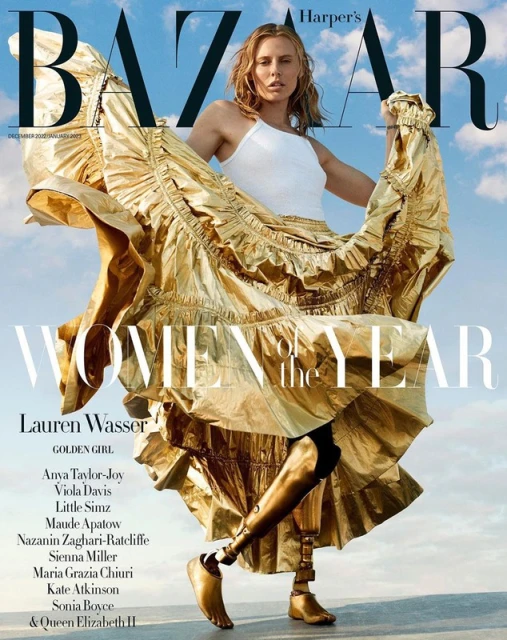 Harper's Bazaar magazine cover featuring Lauren Wasser in a flowing gold dress. She has prosthetic legs and is posing confidently.