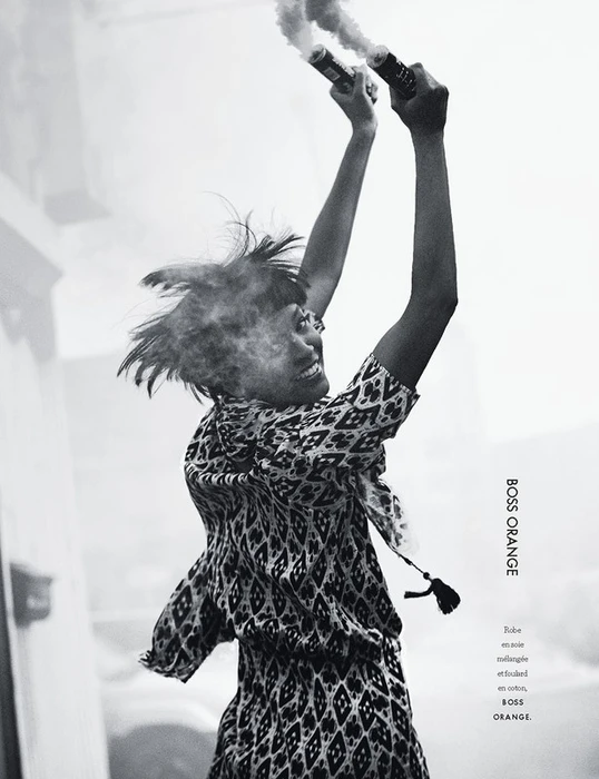 Monochrome portrait of a smiling woman holding up smoke flares in Los Angeles
