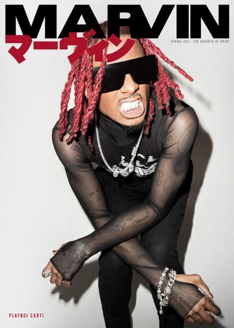 Playboi Carti cover image. Male fashion model in black translucent top with red dreads, statement sunglasses, and jewelry.