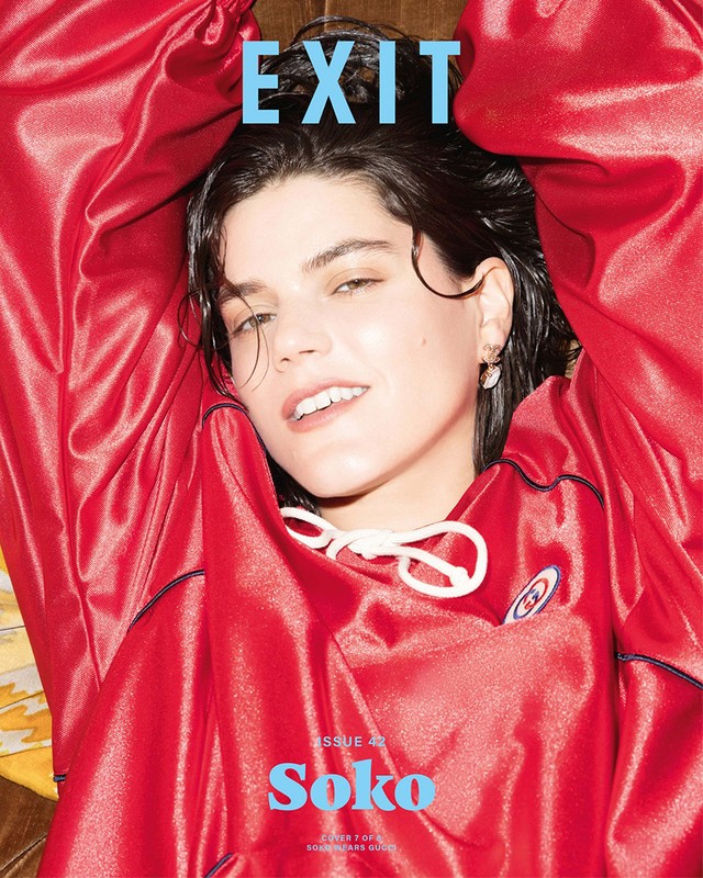 Portrait of a woman wearing a red satin tracksuit with white drawstrings, photographed by Kenneth Cappello.
