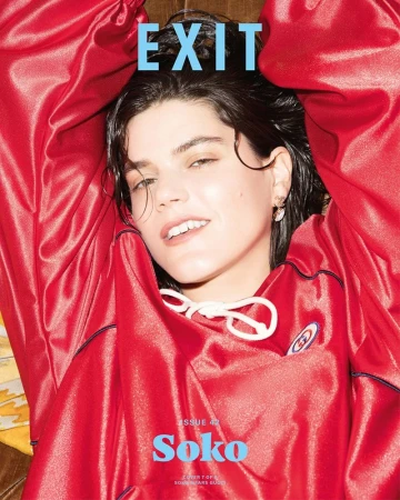 Portrait of a woman wearing a red satin tracksuit with white drawstrings, photographed by Kenneth Cappello.