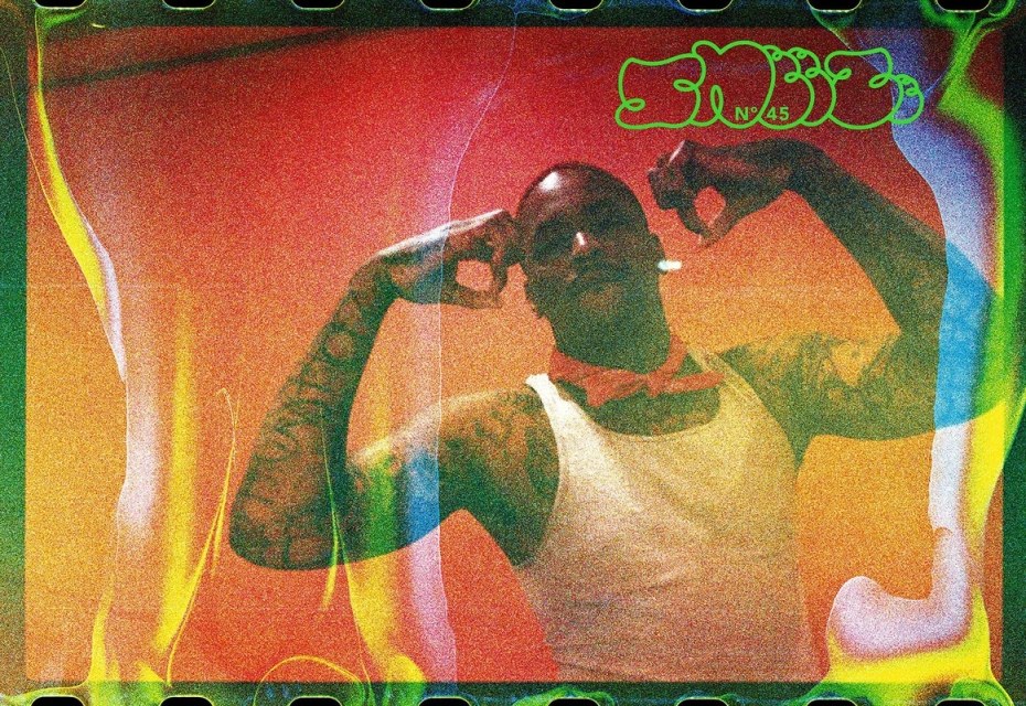 An athletic bald man flexes his arms, enhanced by vibrant orange and green overlays, embodying a unique blend of fitness and artistic expression.