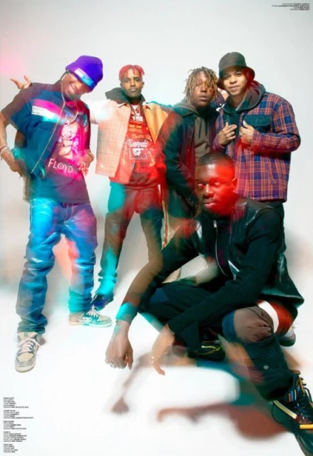 Group portrait of five young adult men in casual streetwear poses against a white backdrop, with light leaks, colorful gel lighting.