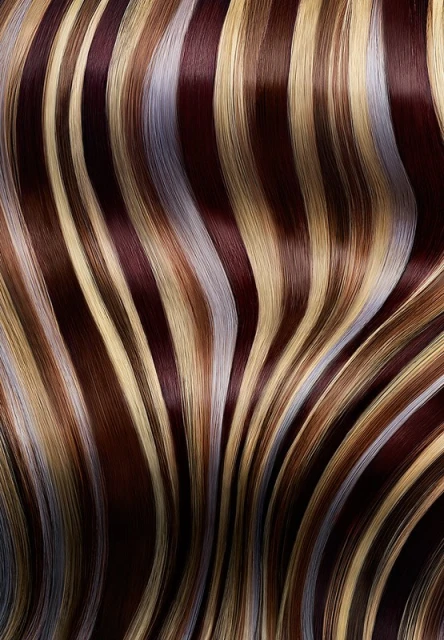 Striking hair highlighting featuring warm blonde, brown, and silver tones creating a dynamic, flowing pattern of color and texture.