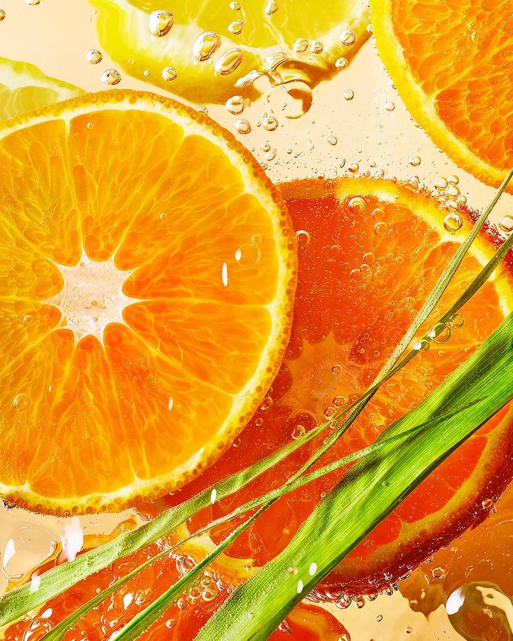 Close-up of fresh orange and lemon citrus slices in water, with vibrant colors and refreshing bubbles, highlighting natural textures and freshness.