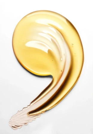 Close-up of a golden yellow cosmetic serum or oil swatch on a white background, showcasing its smooth texture and glossy appearance.