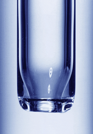Close-up of a clear glass test tube filled with a blue liquid. The curved bottom of the tube is visible in the light.