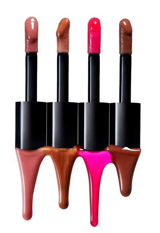 Four lip gloss applicators with black handles and different shades of glossy liquid dripping from the tips against a white background.