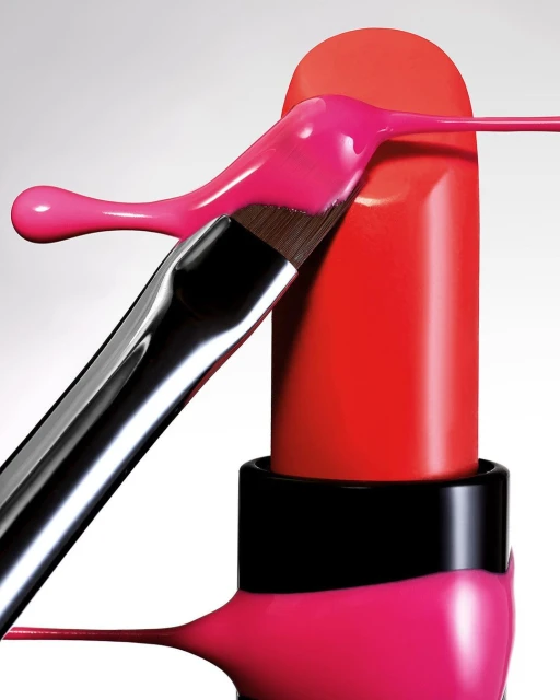 Still life shot of red lipstick with a makeup brush applying pink cream against a white background in vertical format, close-up.