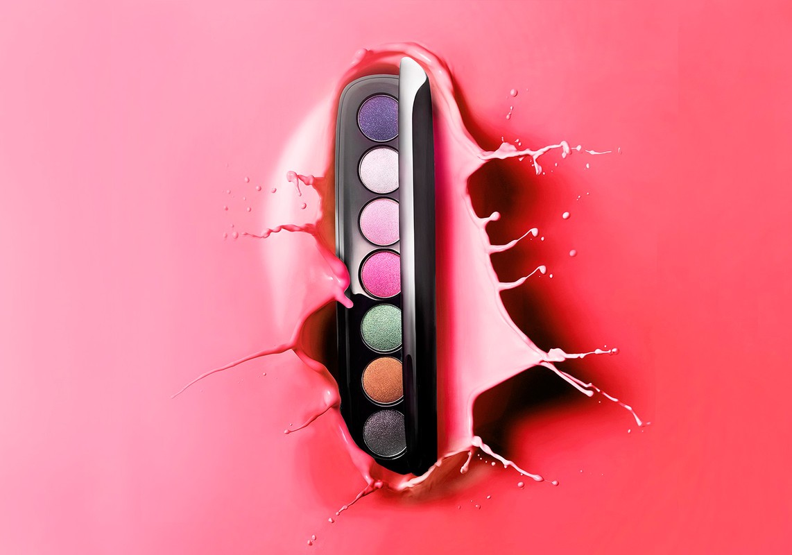 Eye shadow palette against a pink background with a splash of pink liquid surrounding it, for beauty and makeup product photography.