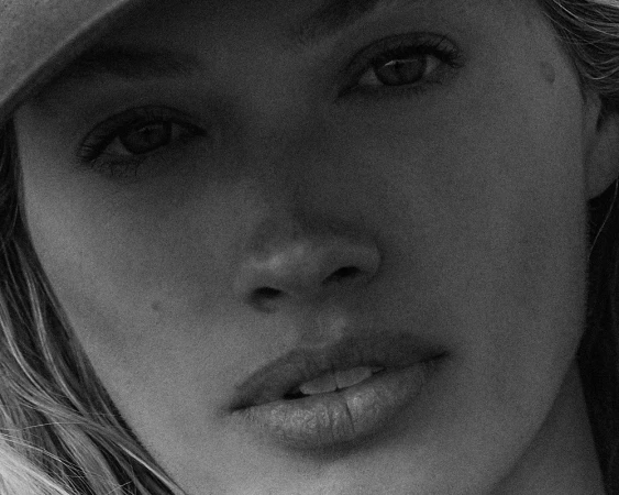 Close-up black and white portrait of a woman wearing a cap by photographer Landon Mcmahon.