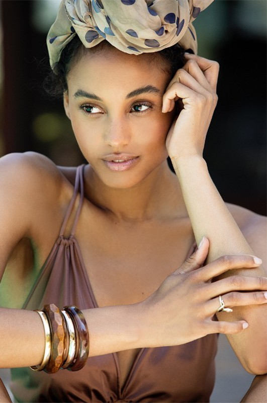 Model in brown top wearing a polka dot headscarf and stacked bangles with make-up by Lauren Lancaster