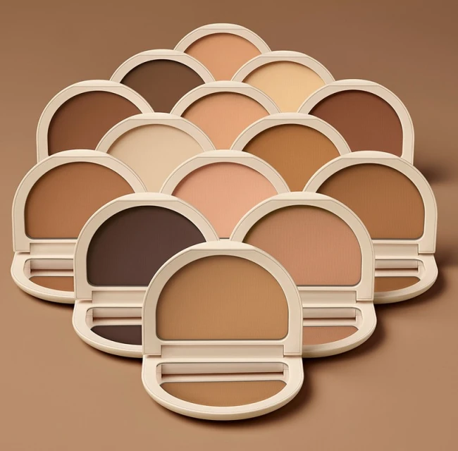 Multiple open and closed compacts displaying makeup foundation shades from light to dark arranged against a complementary background.