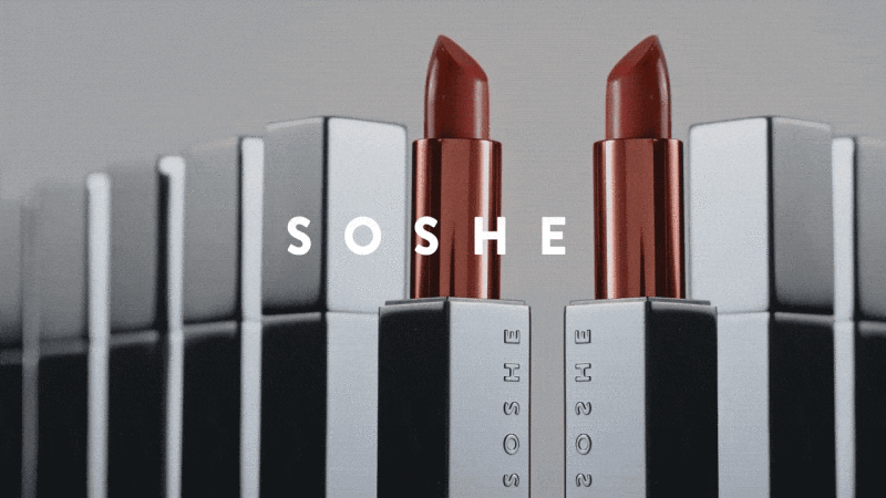 Two red lipsticks in metallic silver rectangular cases aligned in a row with white SOSHE text against a grey studio backdrop.