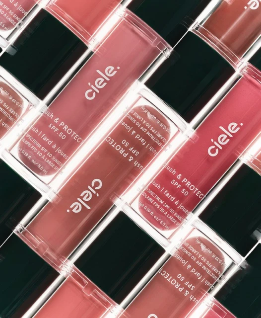 Close-up angled shot of multiple Ciele blush and protect SPF 50 makeup tubes in a repeating pattern with visible text and packaging.