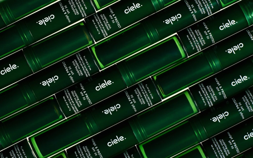 Multiple green Ciele Sculpt & Protect SPF 30 sunscreen sticks are arranged diagonally in a repeating pattern.