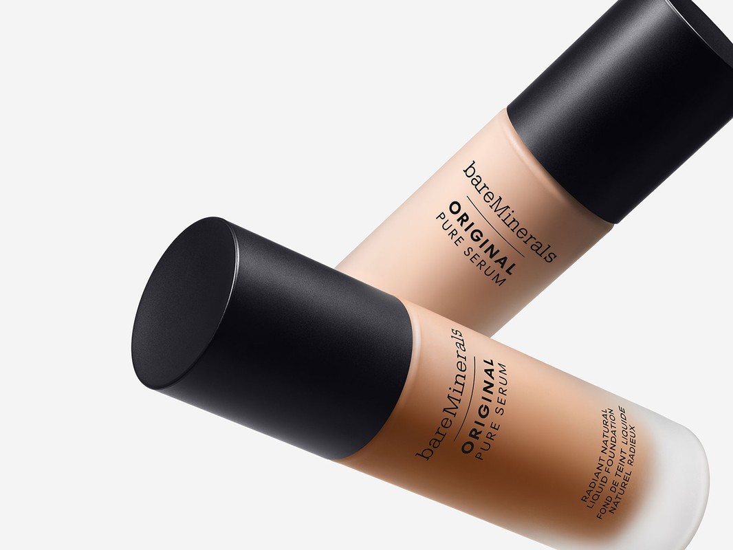 Two bottles of bareMinerals Original Pure Serum liquid foundation in different shades are angled against a solid white background.