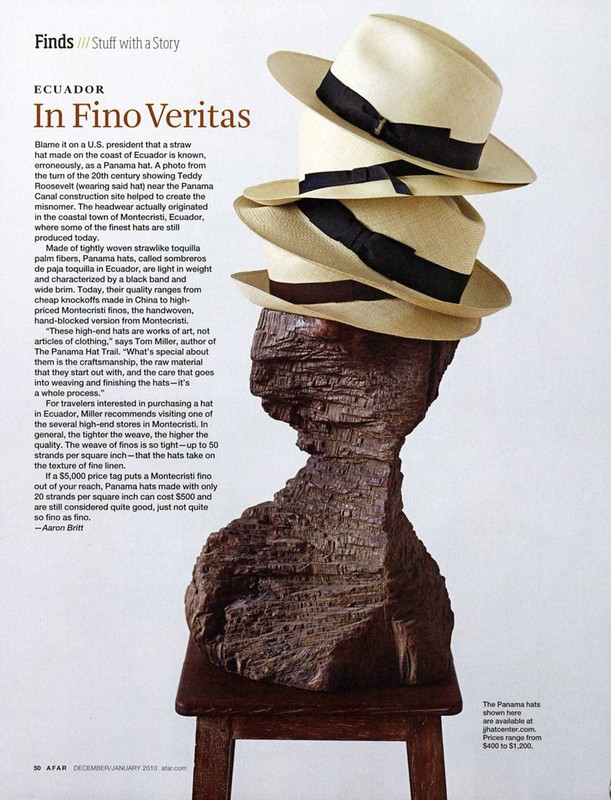 Stack of Panama hats atop a carved wooden bust on a small wooden table, presented in a studio shot for a magazine ad.