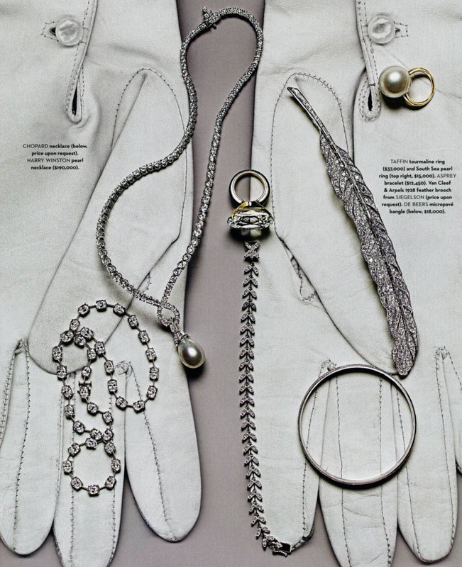 Editorial shot of an array of silver necklaces, rings, and a bangle artfully arranged on white leather gloves.