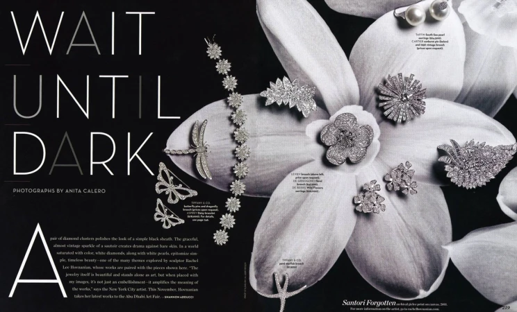 Elegant still life showcases sparkling diamond jewelry pieces arranged on a black background and within a blossoming white flower for a luxurious aesthetic.
