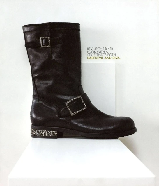 Dark brown leather boot with buckle detail and decorative sole, displayed on a white surface against a white background in a studio shot.