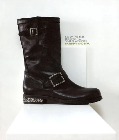 Dark brown leather boot with buckle detail and decorative sole, displayed on a white surface against a white background in a studio shot.