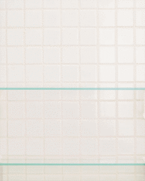 White tiled wall backdrop with two horizontal glass shelves mounted against the surface.