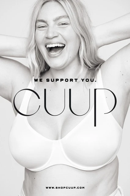 A woman smiles in a CUUP ad, wearing a white bra. She has blonde hair and white teeth. The background is simple, in black and white.