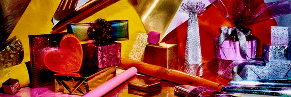 A collection of brightly colored and foil-wrapped gifts and decorations creates a festive and eye-catching still life composition.