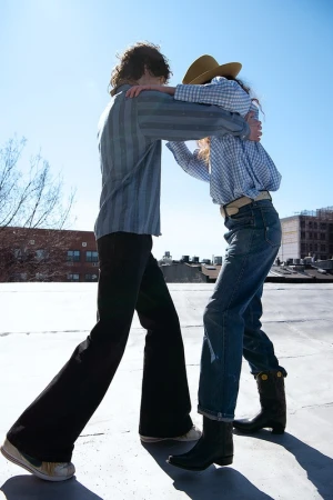 Two people dancing on a rooftop under a clear blue sky, styled by Lorri Sendel in Los Angeles.