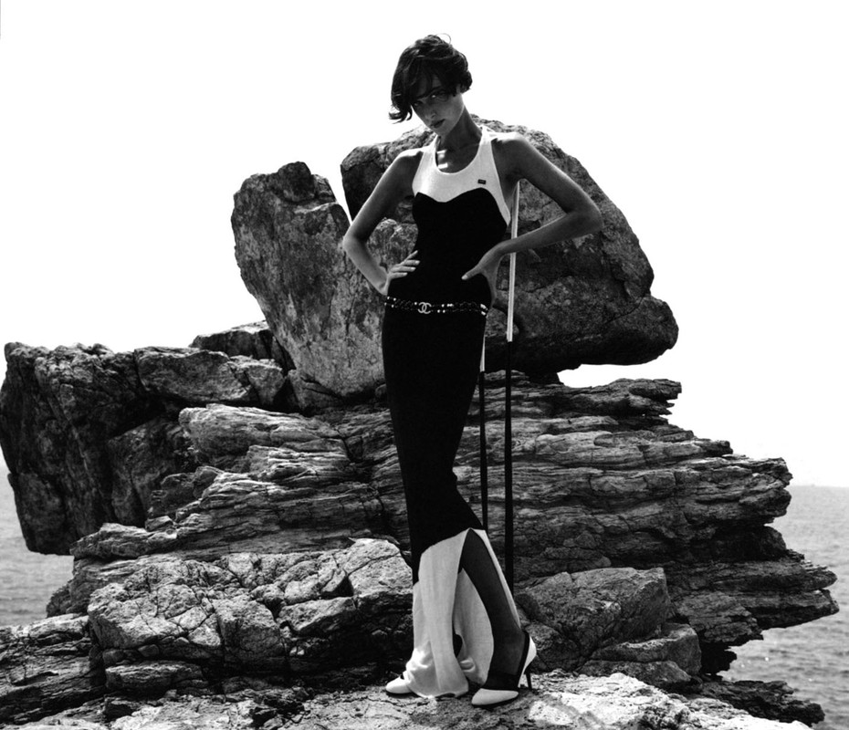 Model standing on rocky coastal shore wearing a two-tone black and white dress styled by Lorri Sendel