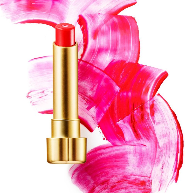Red lipstick with a gold tube displayed against a backdrop of pink, red, and white brushstrokes on a white background.