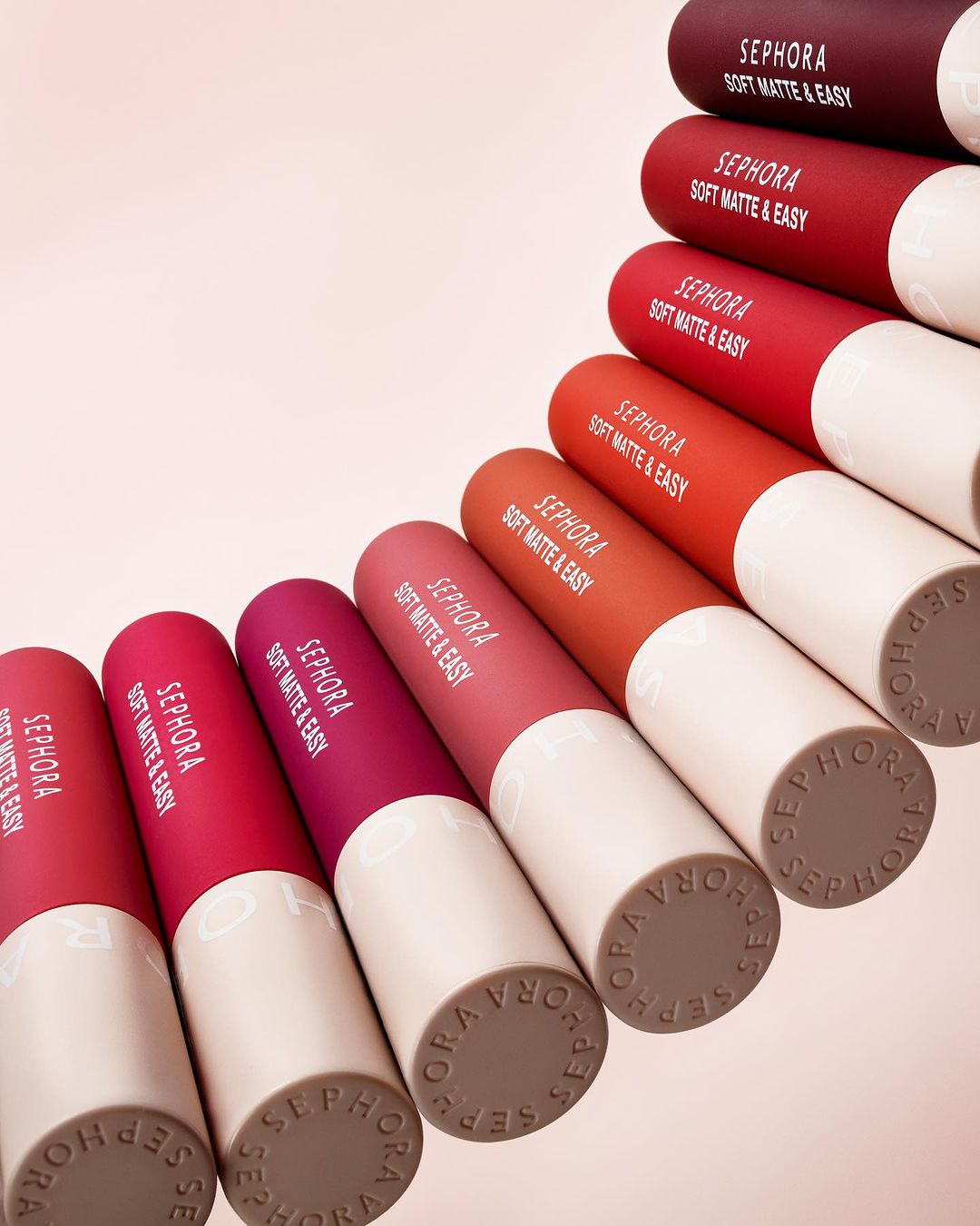 An array of Sephora Soft Matte & Easy lipsticks in varying shades of red and pink, displayed on a light background, showcasing cosmetic products.