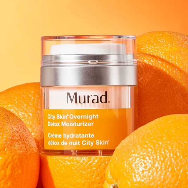 Murad City Skin Overnight Detox Moisturizer jar with oranges in a brightly lit studio setting, product and beauty advertising.