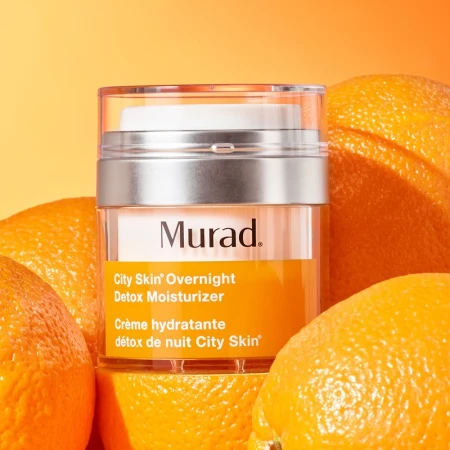 Murad City Skin Overnight Detox Moisturizer jar with oranges in a brightly lit studio setting, product and beauty advertising.